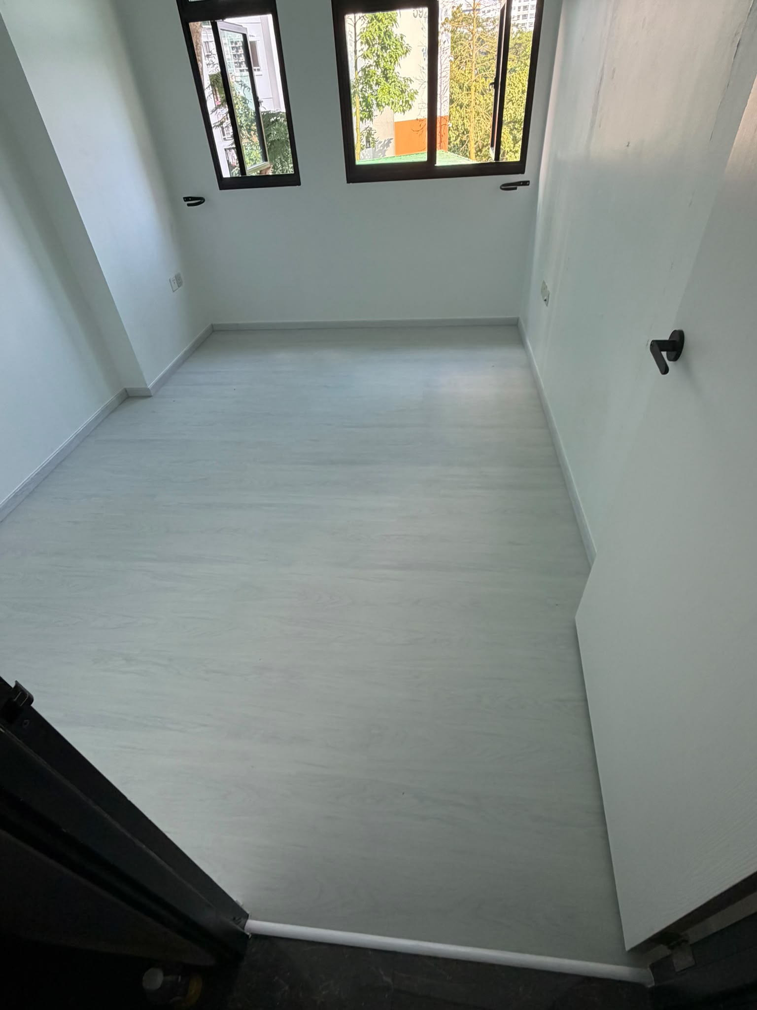 White wood-look vinyl flooring in a bright Singapore bedroom