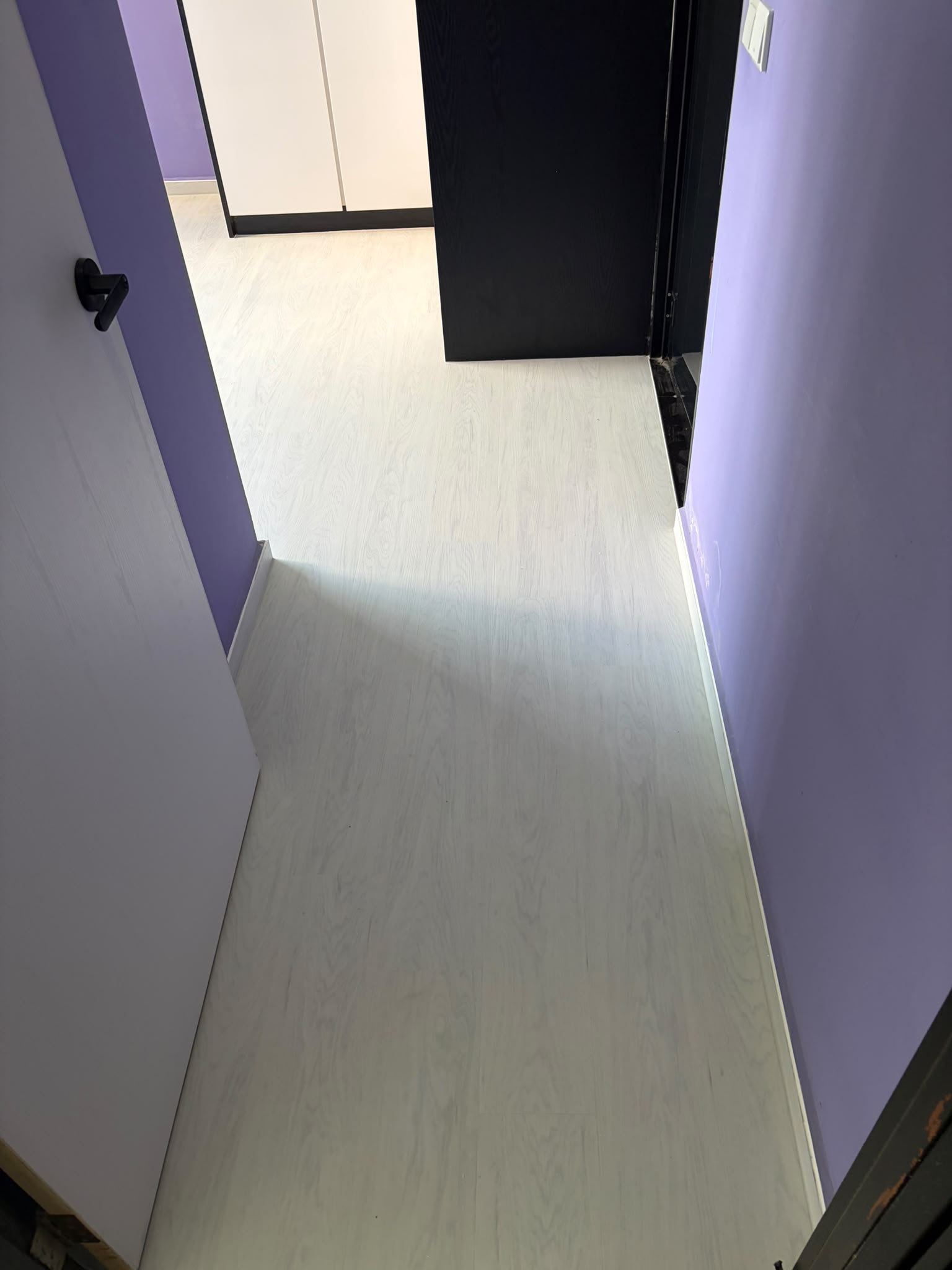 White wood-look vinyl flooring through a Singapore HDB corridor