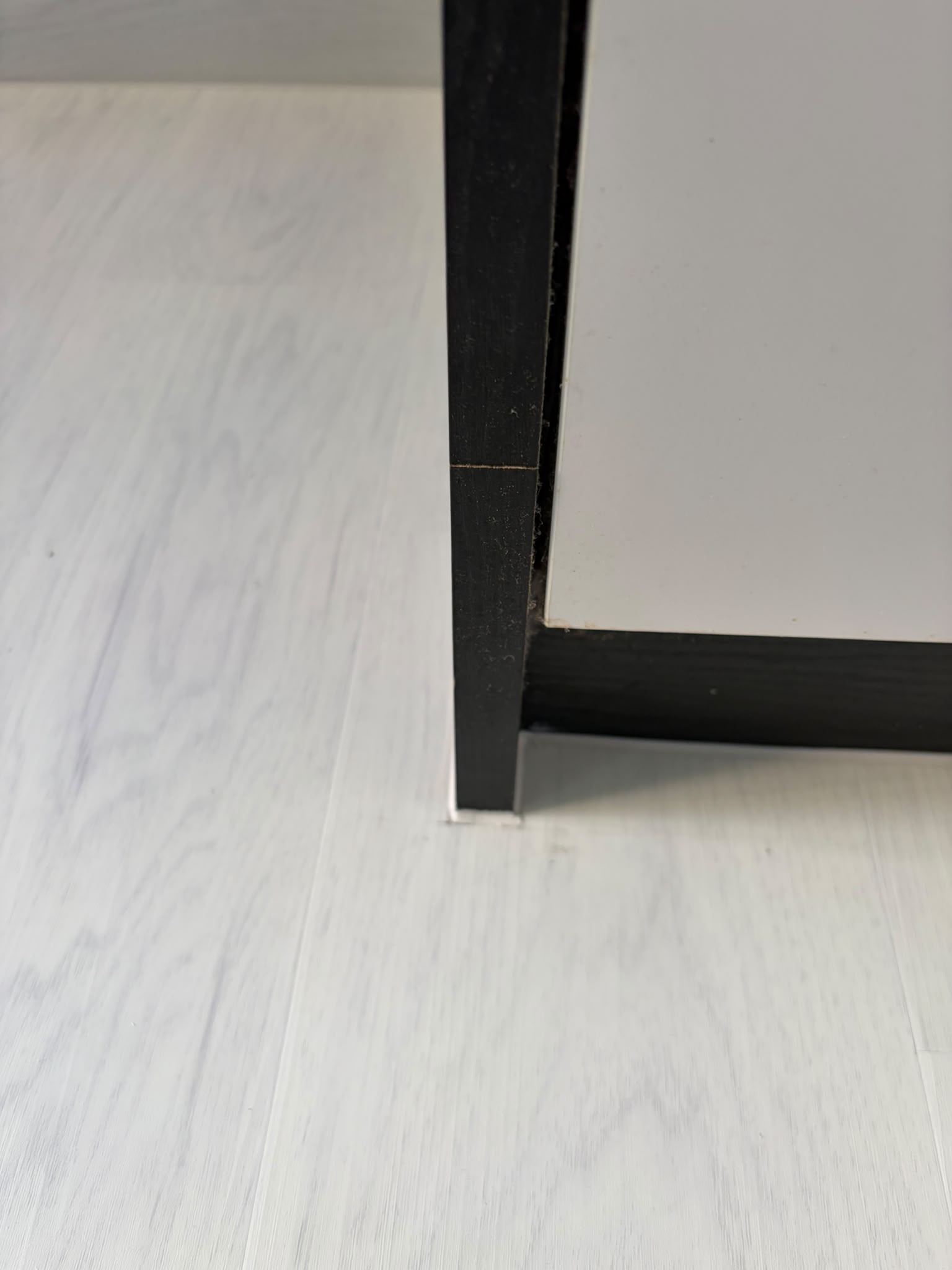 White wood-look vinyl flooring edge beside built-in cabinetry in Singapore